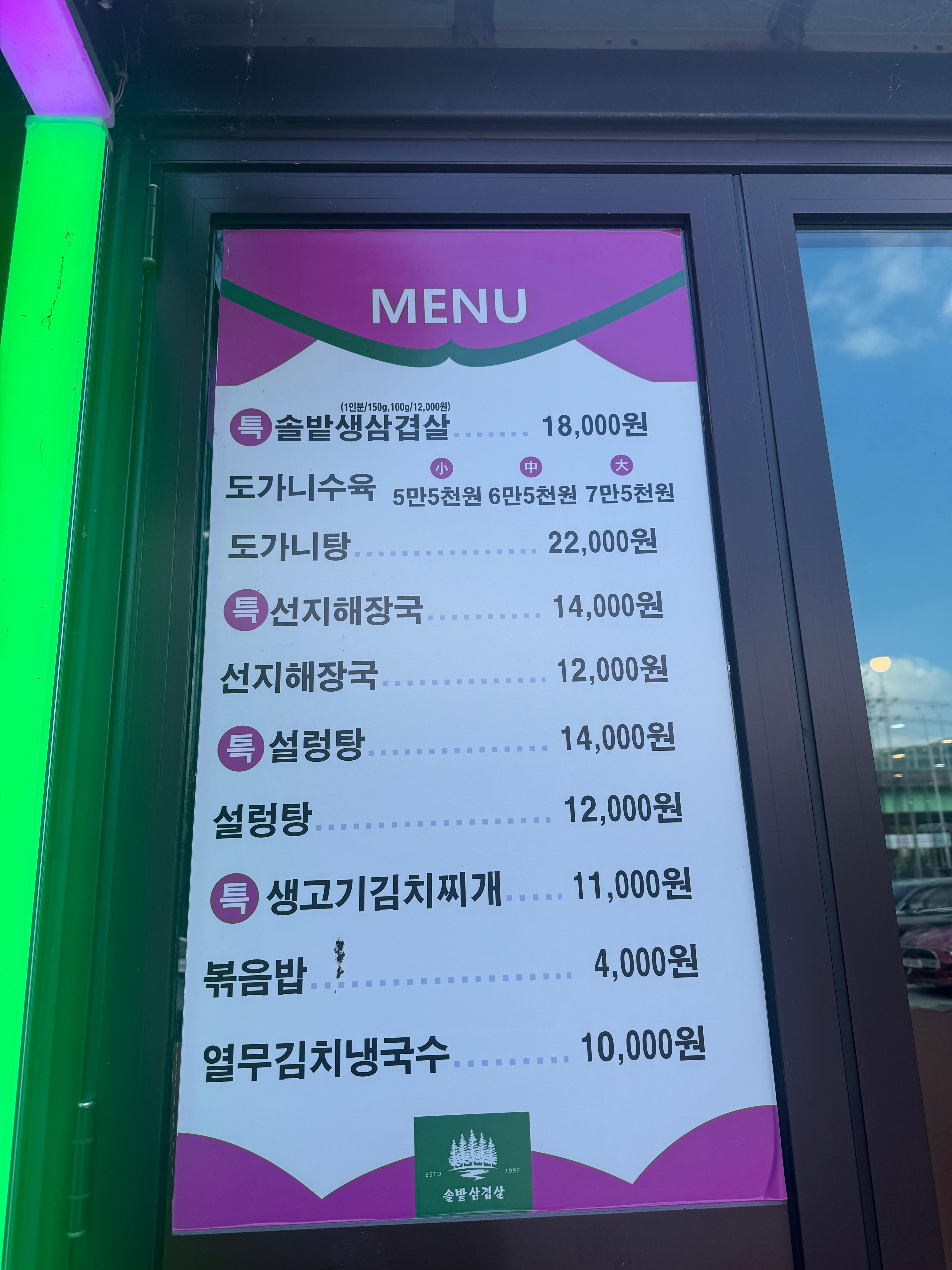 솔밭 삼겹살&amp;해장국 본점 입구에 붙은 메뉴판. 생삼겹살부터 설렁탕&amp;#44; 도가니탕&amp;#44; 선지해장국 등 다양한 메뉴와 가격이 안내되어 있다. 