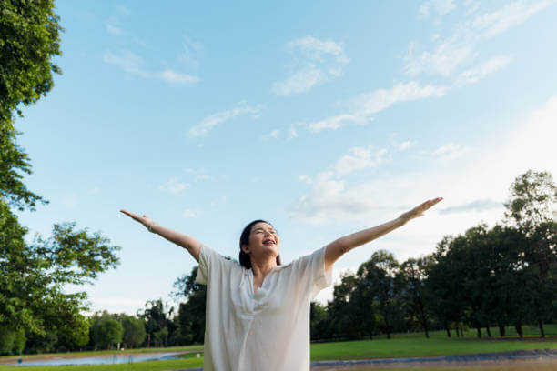 공원에서 팔을 벌리고 자유로움을 느끼는 여성