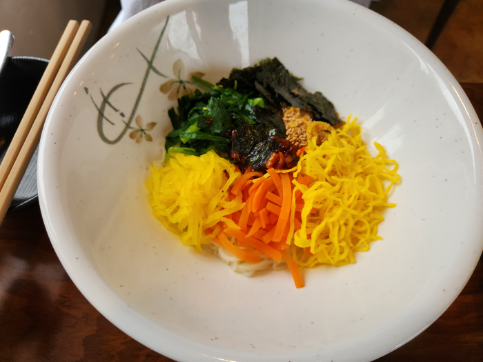5 different colored toppings are placed on top of the noodles