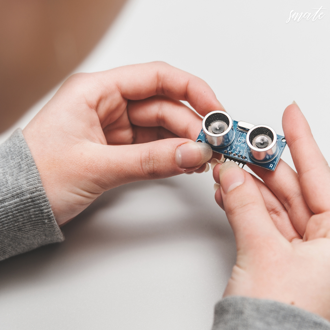 작은 센서를 두손으로 들고 살펴보고 있는 모습
