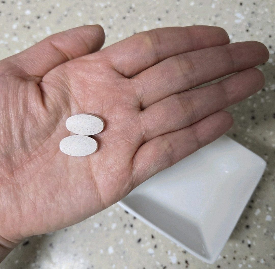 Korean Asian man in 40s comparing different supplement bottles