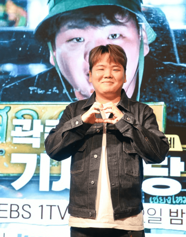 곽튜브 세계기사식당 기자간담회 중에 곽준빈이 손으로 하트를 만들고 사진을 찍고 있는 장면