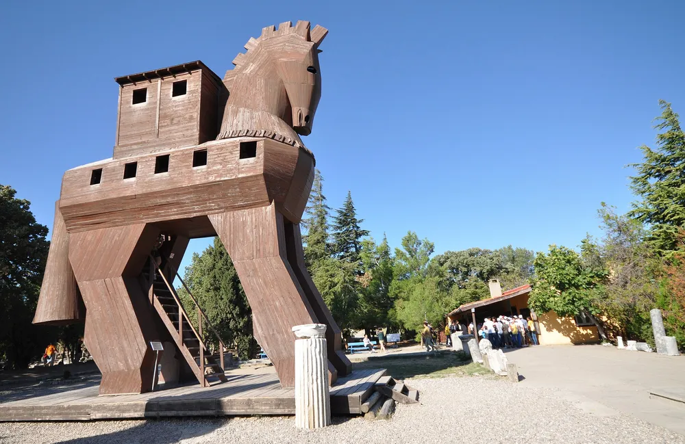 나무로 만들어진 대형 트로이 목마 모형이 야외에 설치되어 있다. 말의 배에는 사각 창문이 있으며, 다리 아래에는 사람들이 내부로 들어가는 계단이 놓여 있다.