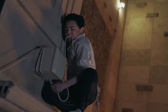 벽을 타고 탈출하려는 이용남(조정석)