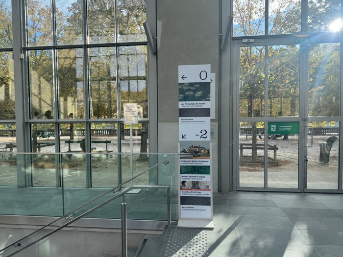 Musée de l'Orangerie interior direction sign indicating Water Lilies and Monet temporary exhibition.