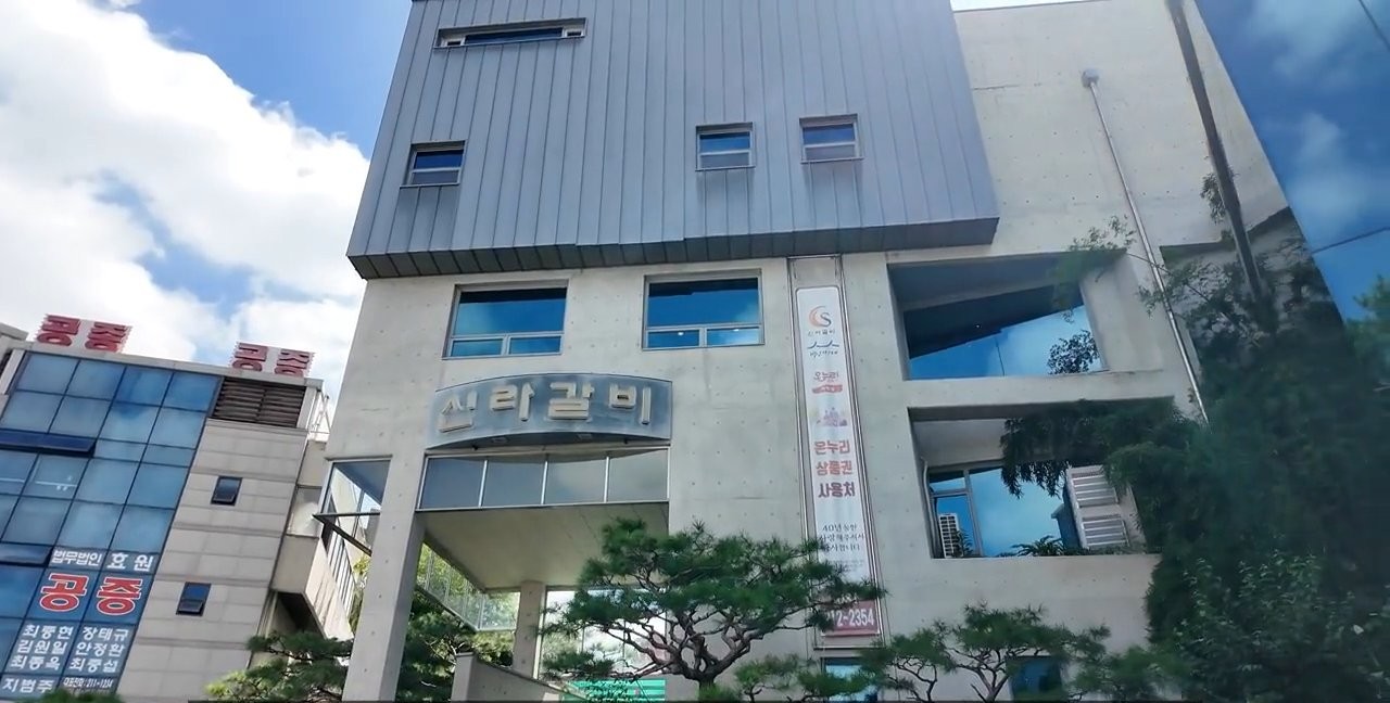 파란 통유리 건물에 신라갈비 간판이 크게 걸려 있어요.
