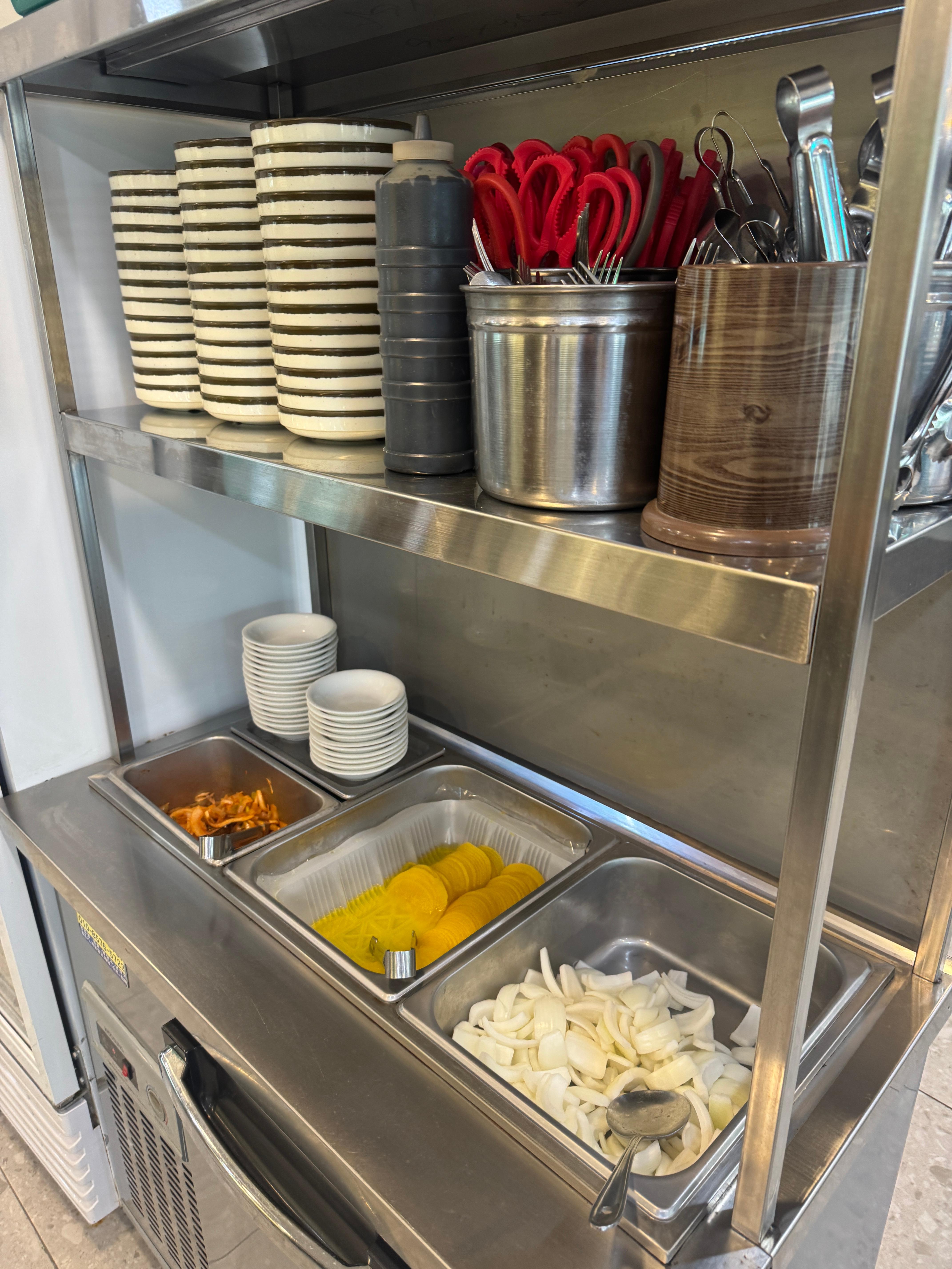 넘버1고기짬뽕의 셀프 반찬바 &ndash; 단무지&amp;#44; 양파&amp;#44; 김치와 집기류 정리된 모습