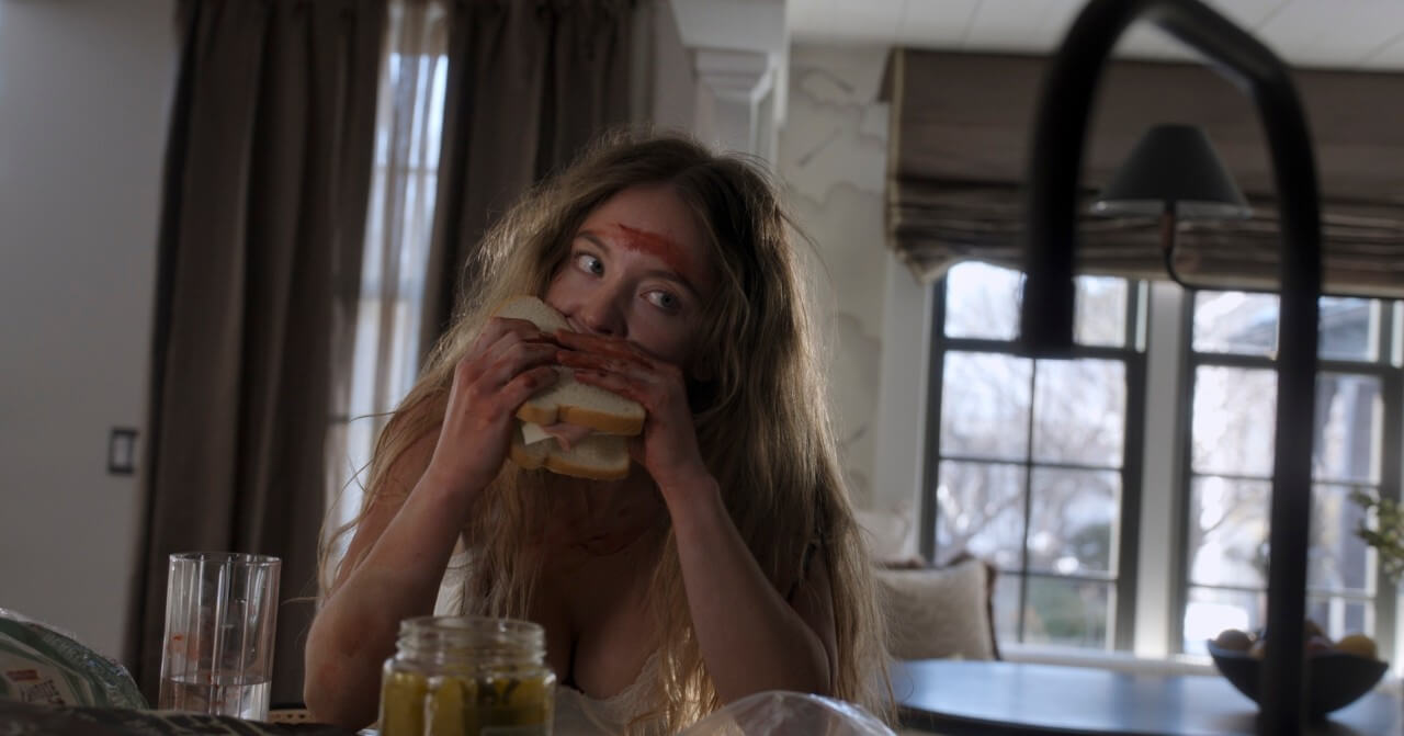 이마에 피를 묻힌 채 샌드위치를 물고 있는 여자