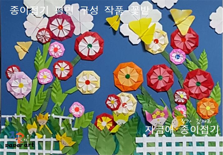 문양 접기로 꽃을 만들어 꽃밭을 꾸민 모양이며, 하얀색의 울타리가 있는 모양입니다.