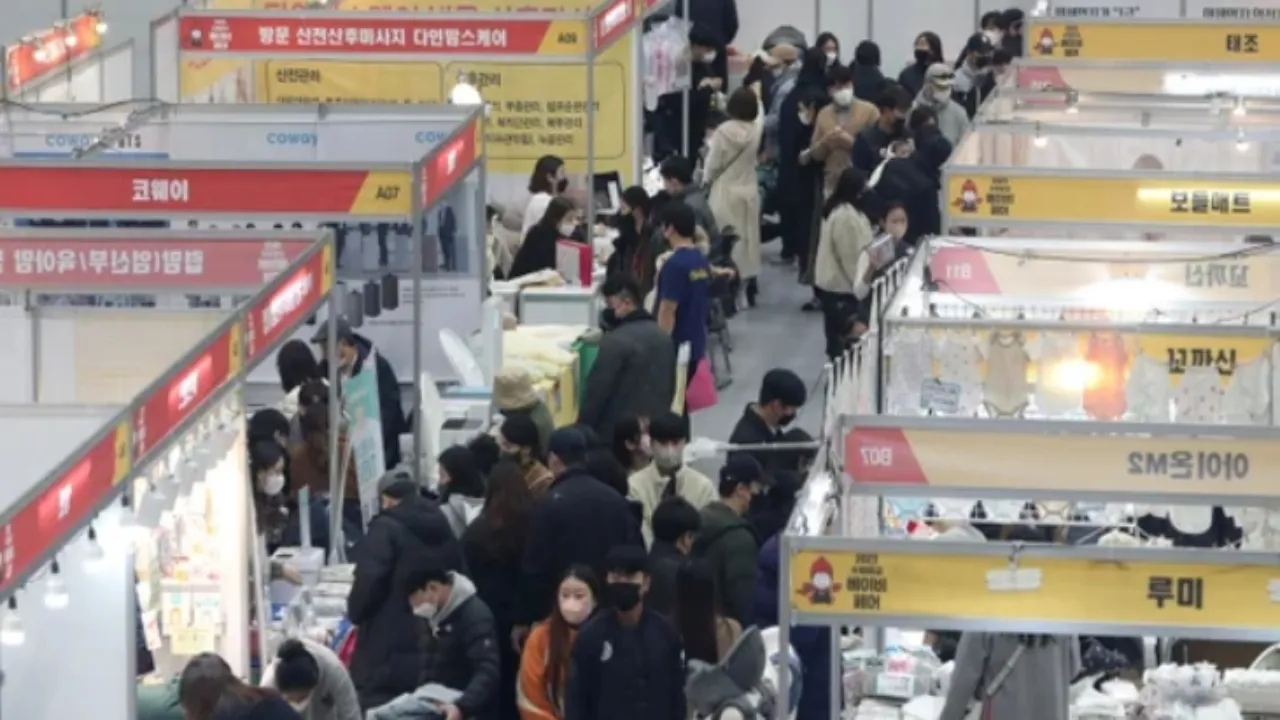 수원베이비페어 전시장 내부 전경을 담은 이미지입니다. 다양한 브랜드 부스와 관람객들이 붐비는 모습이 보입니다.