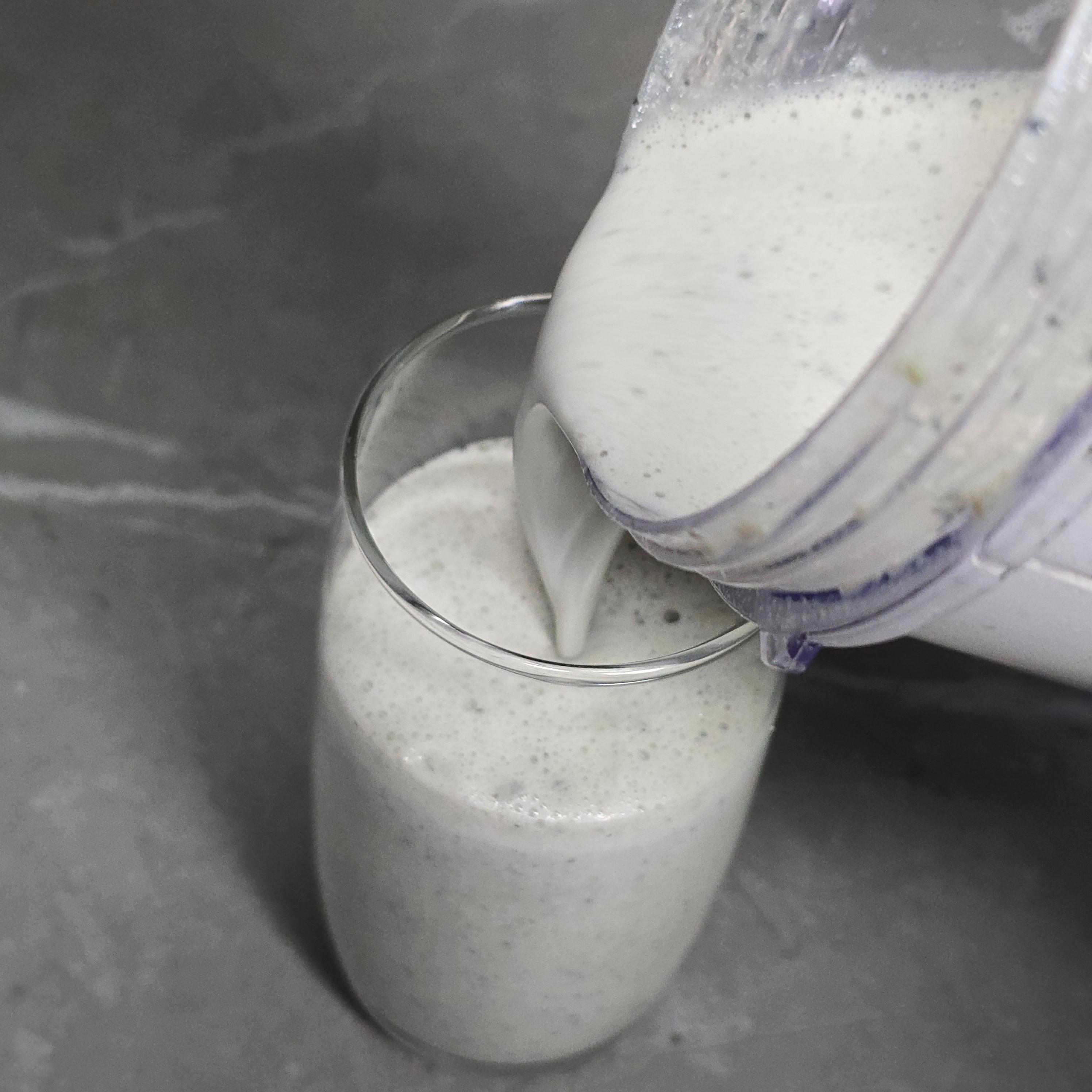 컵에 따르고 있는 부드러운 질감의 검은콩 두유