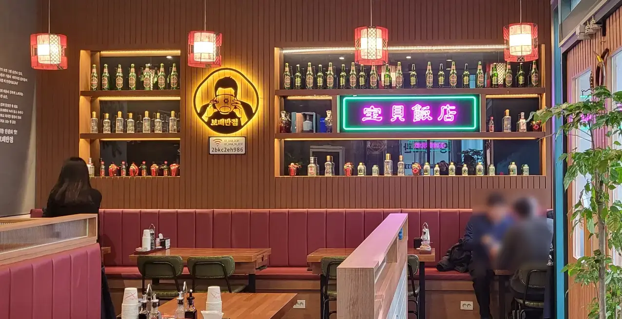 보배반점 -
나무로 된 벽면 양쪽 사각형으로 파인 공간 안 거울이 붙여있으며 그 앞으로 각족 주류들이 3줄로 배열된 벽면 아래 벽면으로 길게 붙은 소파와 테이블