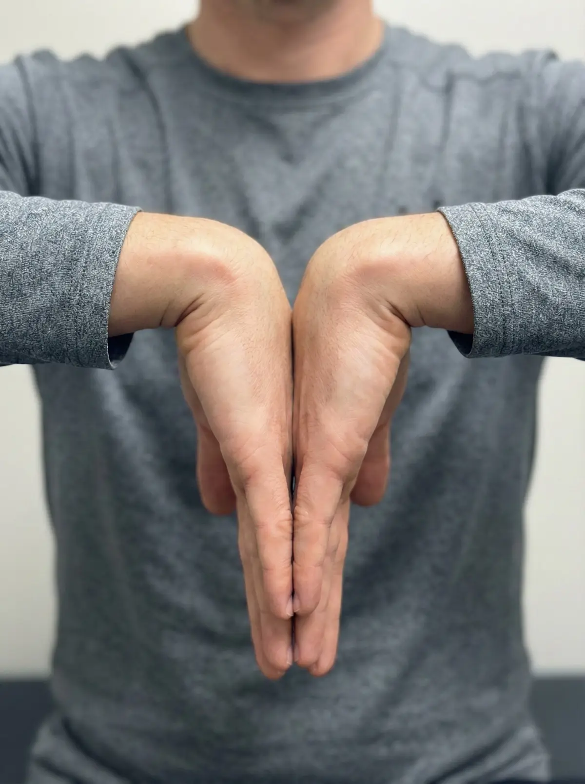 양 손등을 서로 맞대고 손목을 90도로 꺾어 가슴 앞에 둔 팔렌 테스트 자세