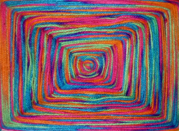 무지개 색의 화려한 양모 털실이 사각형 형태로 정리된 모습