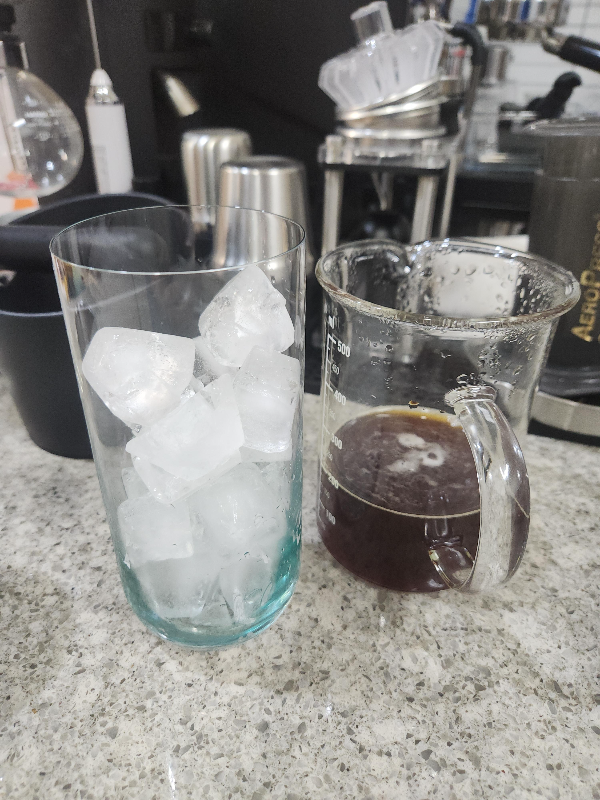 얼음컵과 추출된 커피가 담긴 서버가 함께 놓여 있다.
