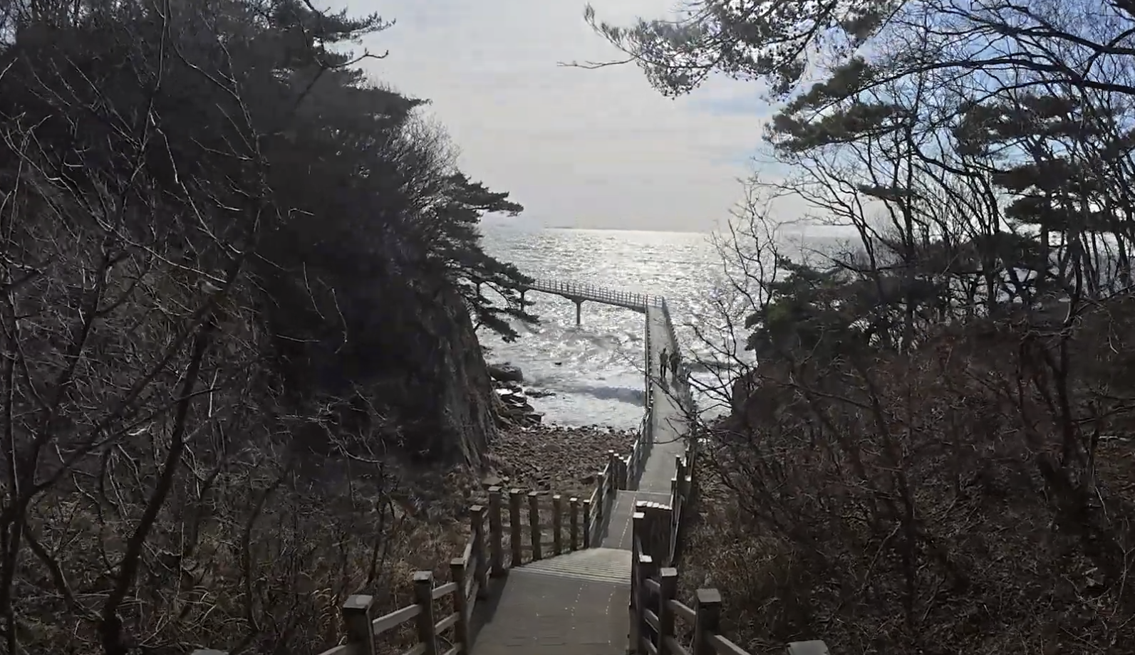 무의도의 암벽 기슭을 타고 내려가는 해상관광탐방로가 바다로 이어지고 있다 