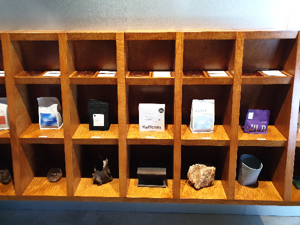 격자 장식장에 원두들이 있다. 가장 위쪽은 시향. 중간은 원두 패키지. 아래는 장식물들이 보인다.