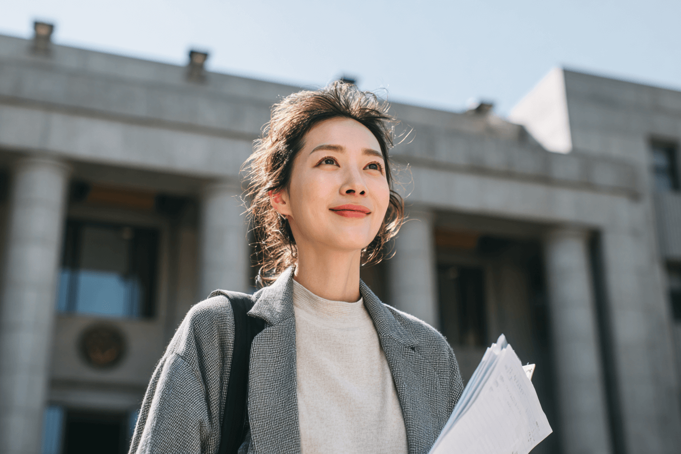 법원-앞에서-서류를-들고-있는-여성