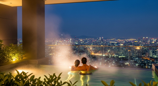 은은한 조명이 켜진 낭만적인 야외 나이트 스파의 전경과 휴식을 취하는 모습