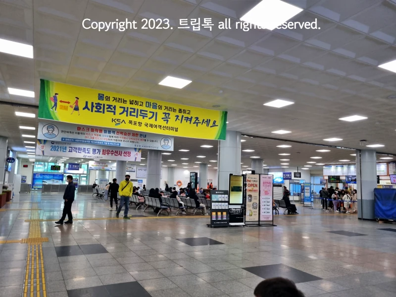 터미널 내부에 노란 현수막과 의자가 많은 대기공간이 있다.