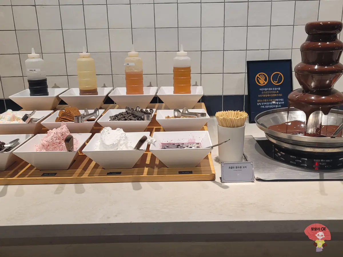 경기-남양주시-다산-애슐리퀸즈-와퍼를-위한-재료들-크림-시럽-등과-초콜릿-퐁듀가 진열되어-있는-이미지