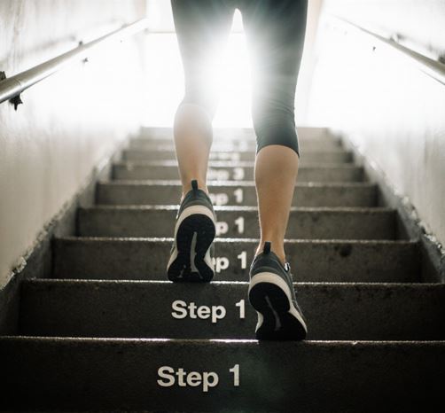 계단을 한 걸음씩 올라가는 사람의 발