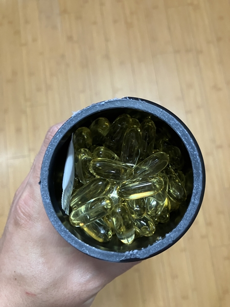 스포츠리서치 트리플 스트렝스 오메가3 병 내부 &ndash; 황금빛 소프트젤이 가득 담긴 모습