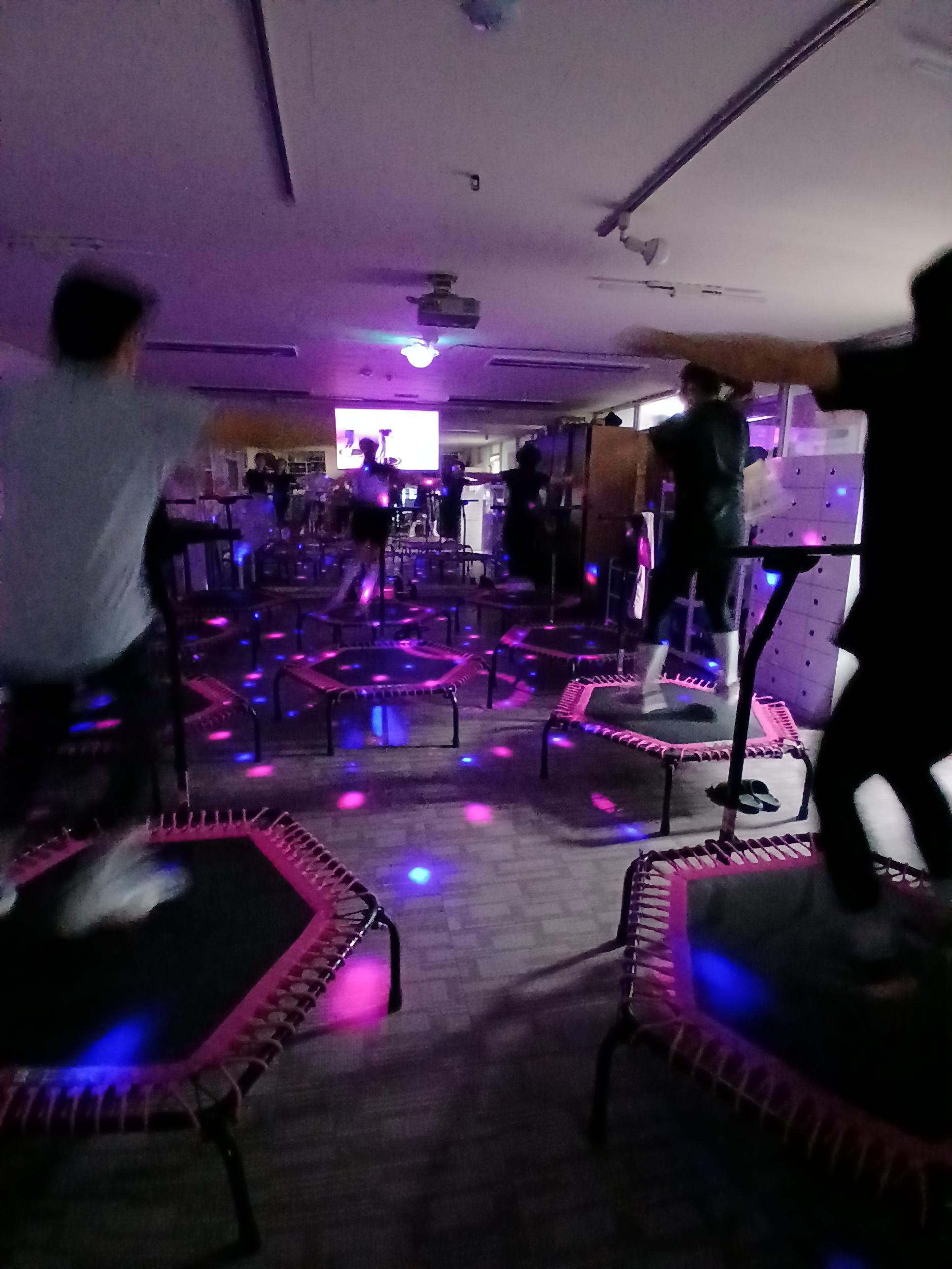 트램펄린(점핑) 운동의 현장 분위기.사이키 조명 아래서 신나게 점핑합니다.