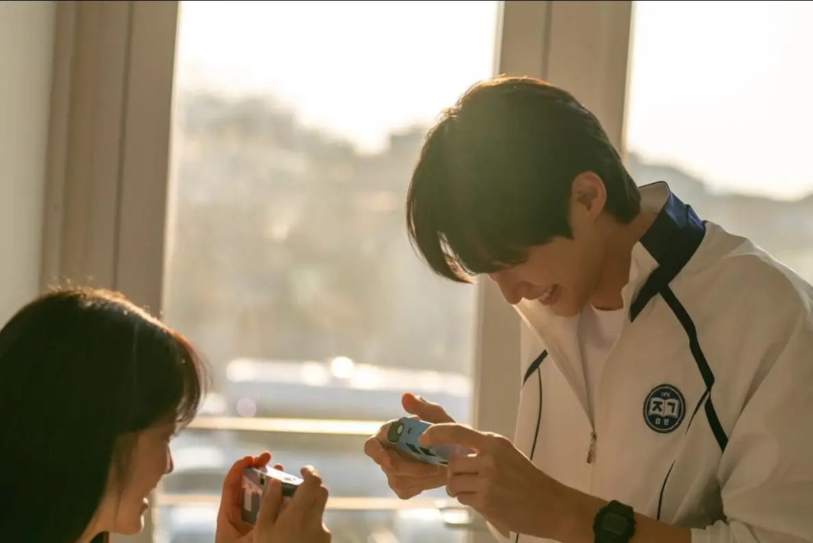 햇빛이 빛나는 창문배경 여자친구와 함께 핸드폰을 보며 웃는모습