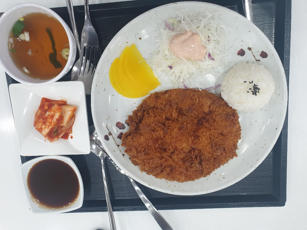 돈가스와 소스 밥 그리고 김치 국물이 보인다.