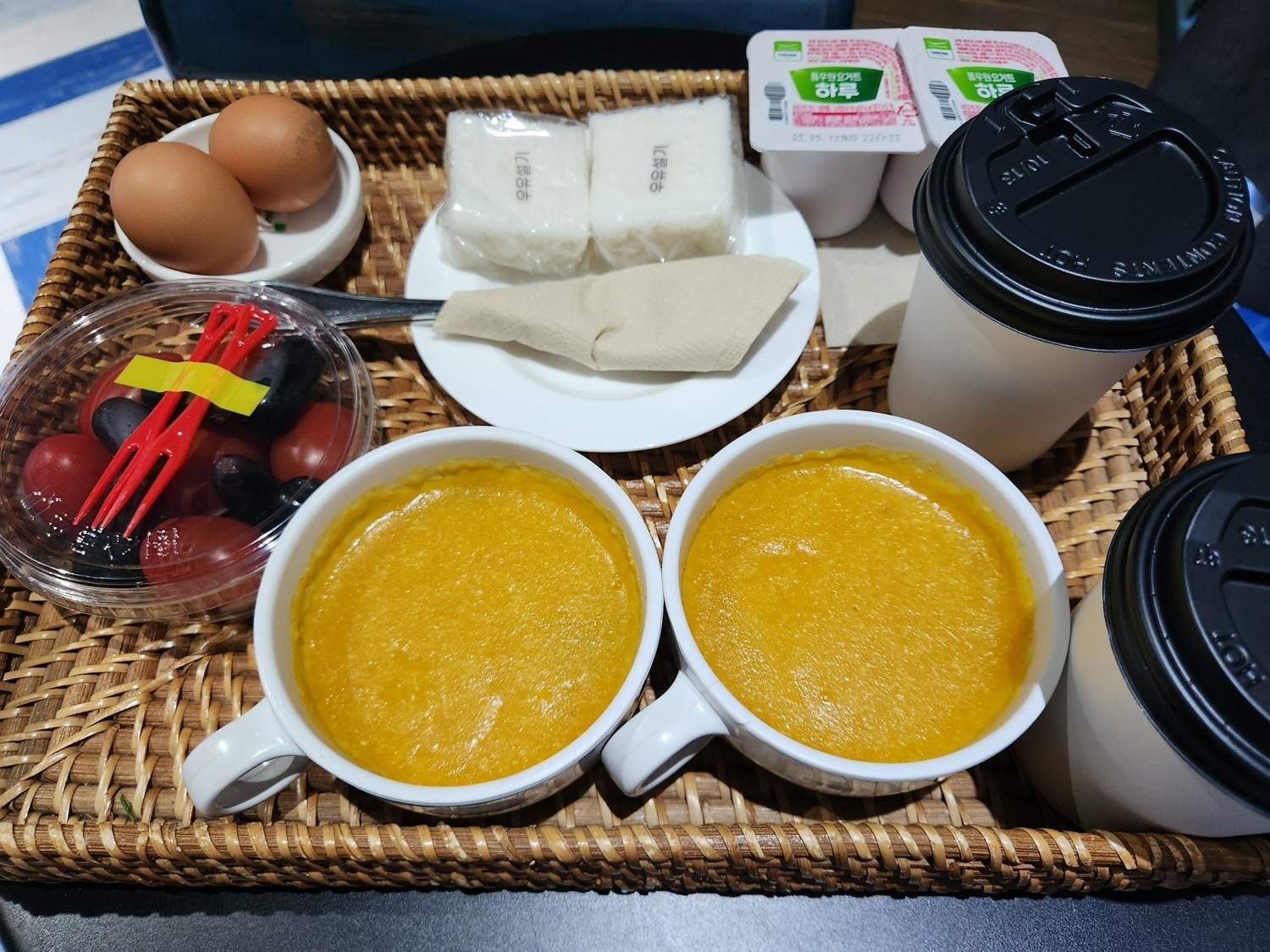 호박죽&amp;#44; 커피&amp;#44; 과일&amp;#44; 계란 떡이 쟁반에 담겨 있다