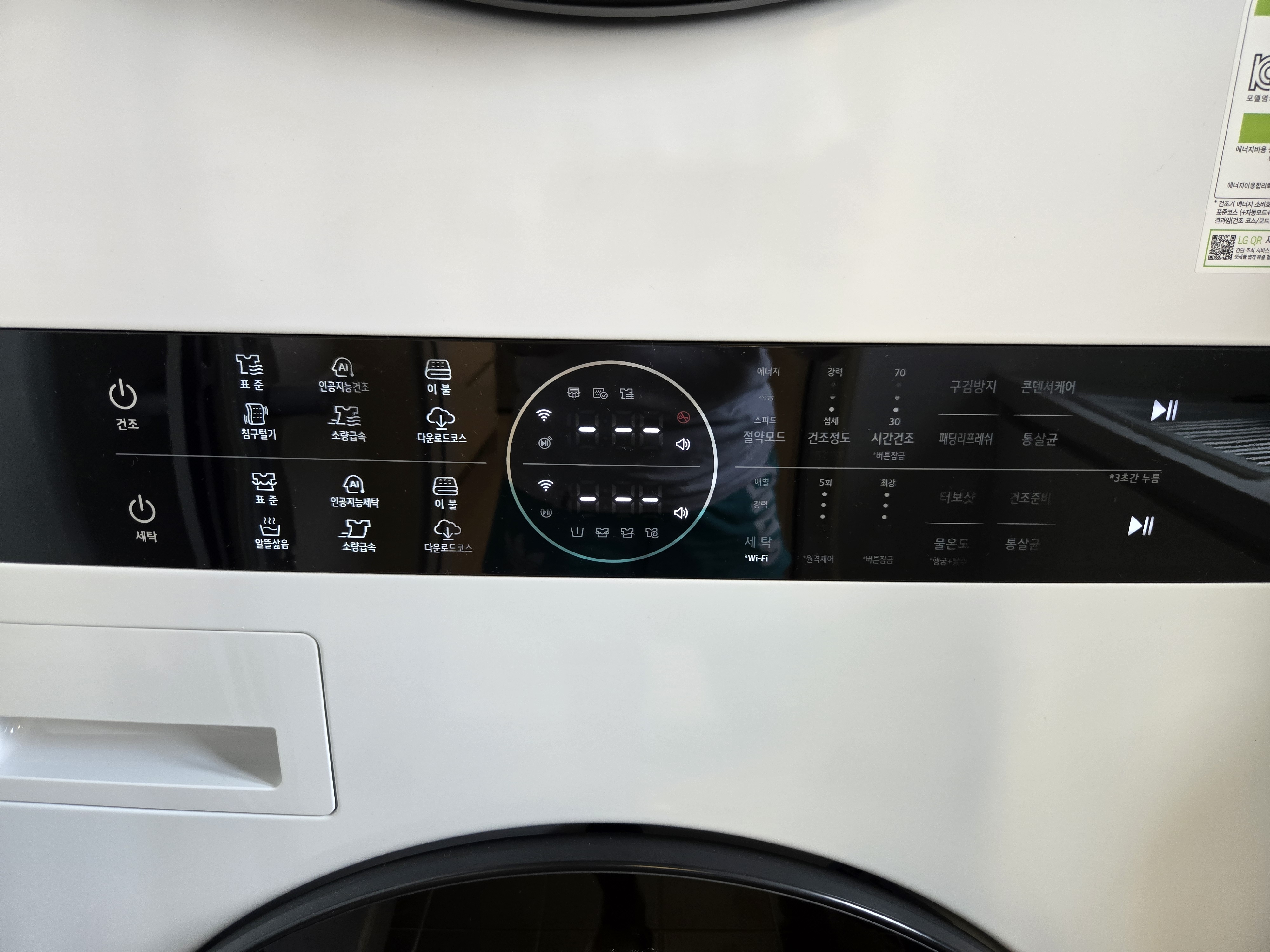 LG 워시타워 상단의 조작 버튼과 원형 터치패널을 클로즈업한 사진