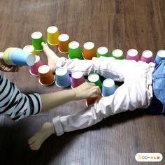 아이와-놀이하면서-주변으로-형형색색의-종이컵을-놓고-꼼짝-못하게-하는-장면