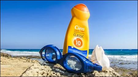 바닷가에 놓인 선크림 통과 물안경