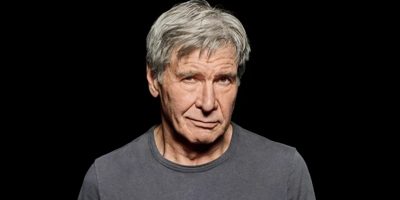 검은색 배경으로 한쪽 입꼬리를 올리고 있는 백발의 해리슨 포드