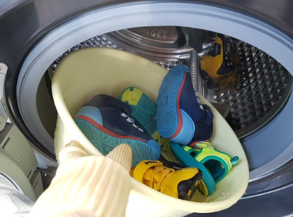 운동화를 세탁기에 돌리려는 이미지