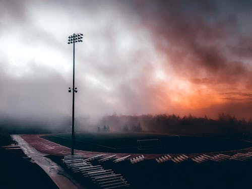 장마철 안개 낀 운동장과 흐린 일몰