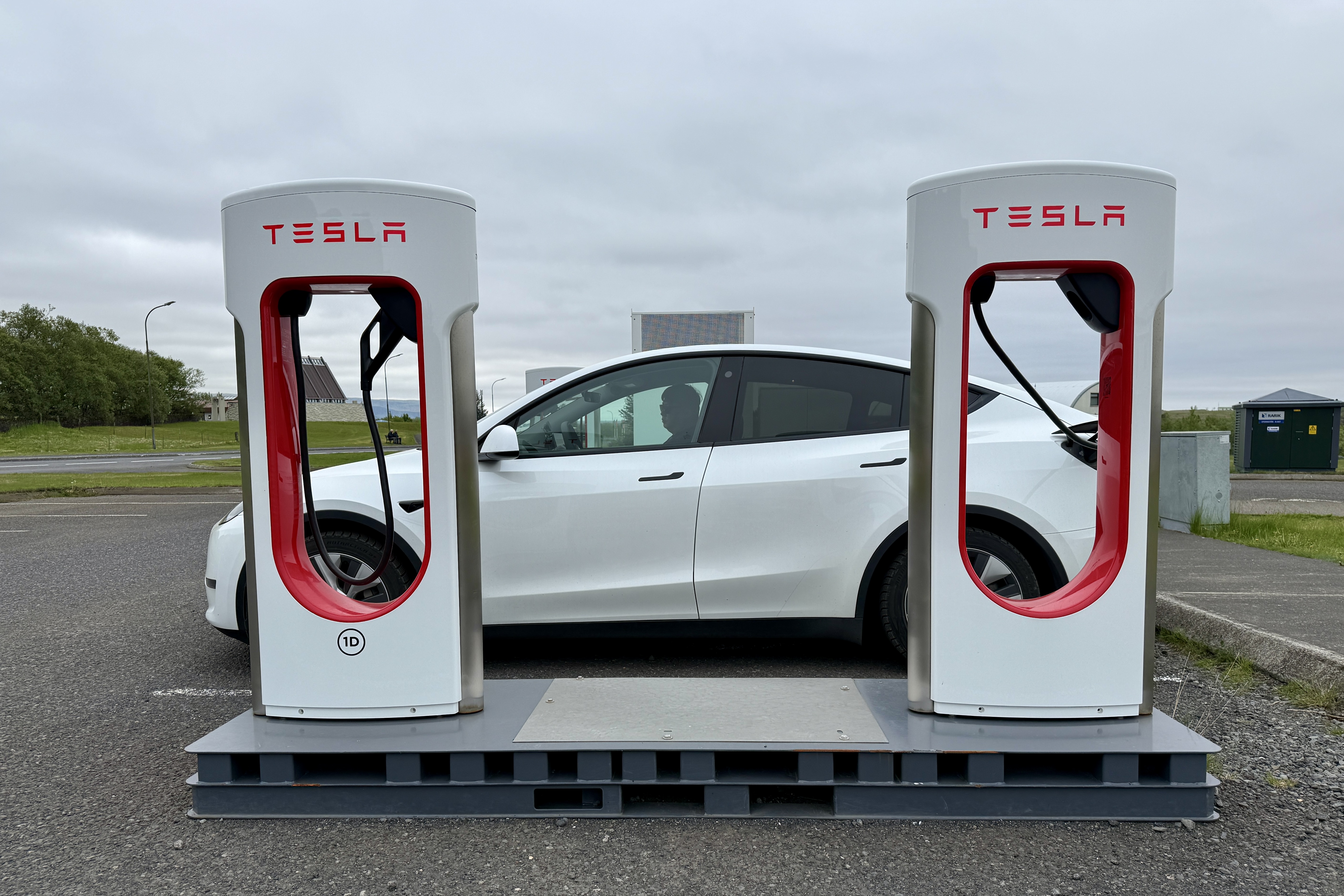 아이슬란드 도로변 테슬라 슈퍼차저 스테이션에서 충전 중인 흰색 테슬라 차량