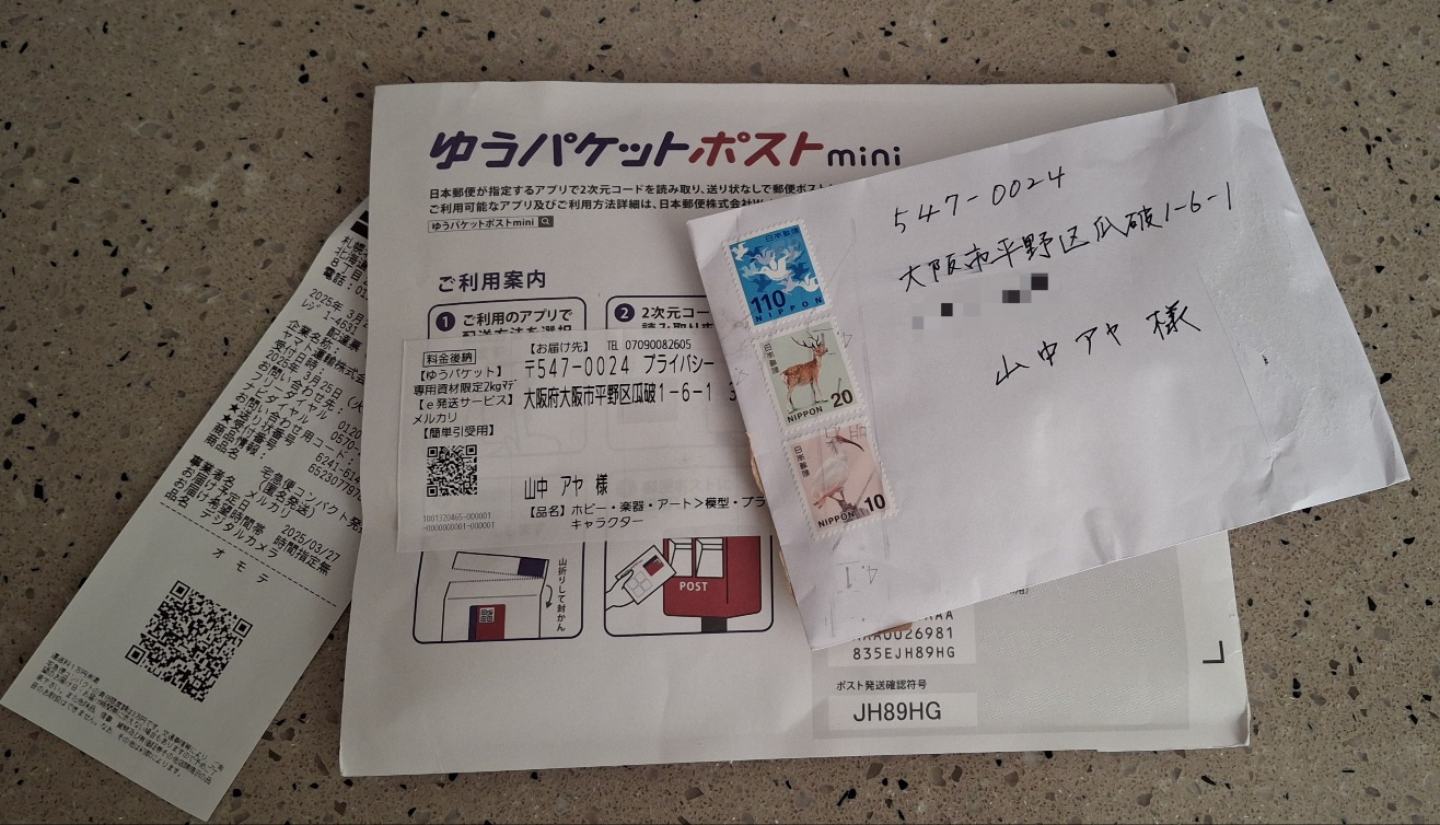 메루카리 구매 상품이 일본에서 발송된 모습을 보여주는 사진으로, 박스와 우편물이 함께 담김