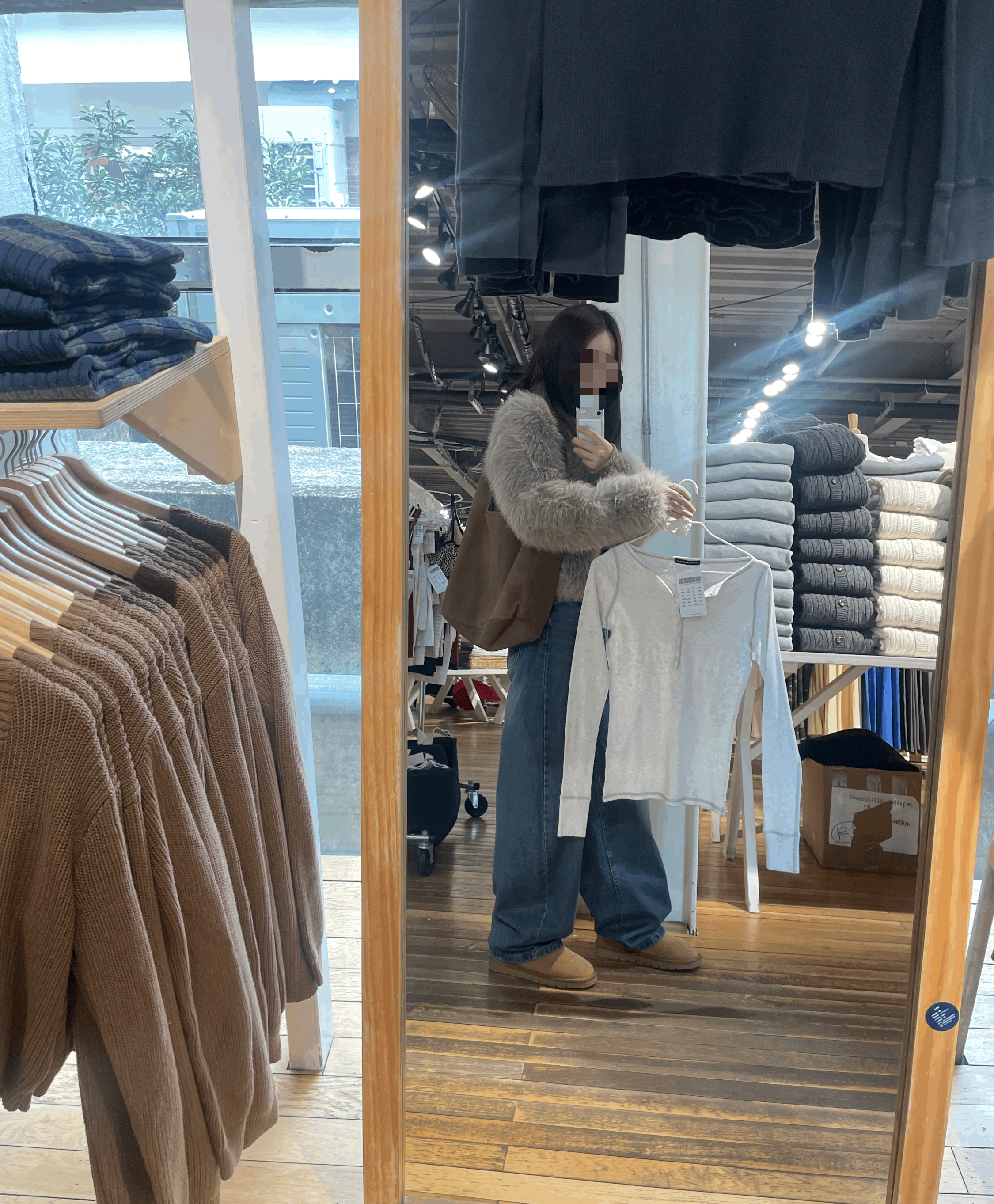 상하이 Brandy Melville 브랜드 멜빌에서 거울을 보고 옷을 들고 있는 모습