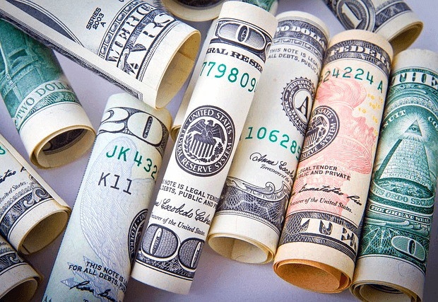 둘둘 말린 달러 지페 여러개가 모여있다.