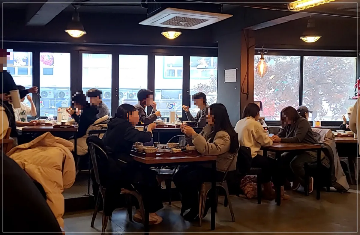 제나키친식당내부 통창에 외부가 보이고 테이블마다 손님으로 가득차 있음