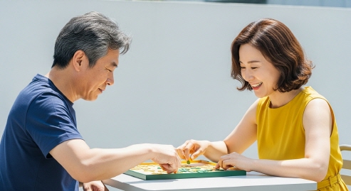 퍼즐 게임으로 서로 점수 경쟁하는 중년 부부