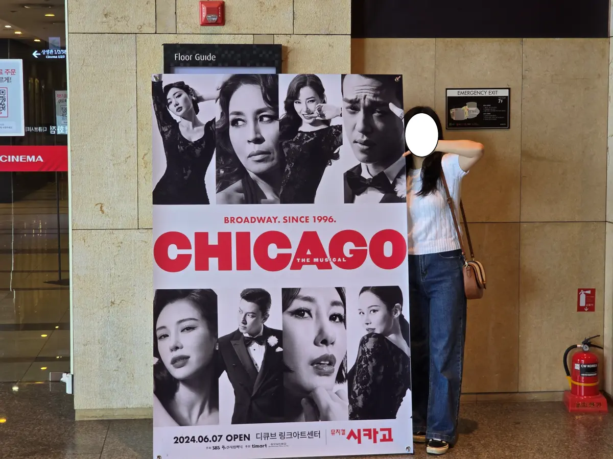 시카고 공연장 앞 입간판과 함께 찍은 여자의 사진