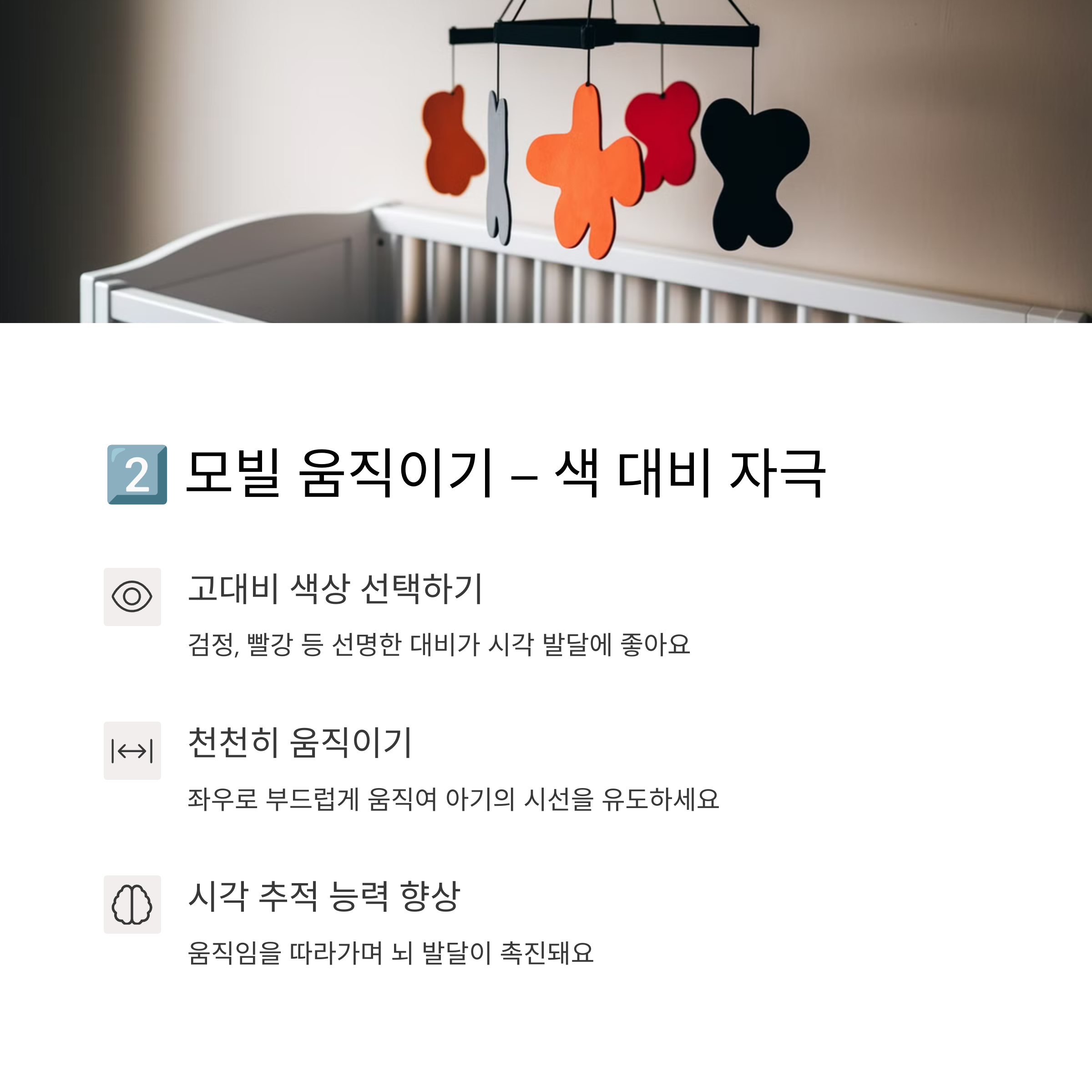 붉은색, 검정색 모양의 모빌을 아기 침대 위에 매달아 놓은 모습