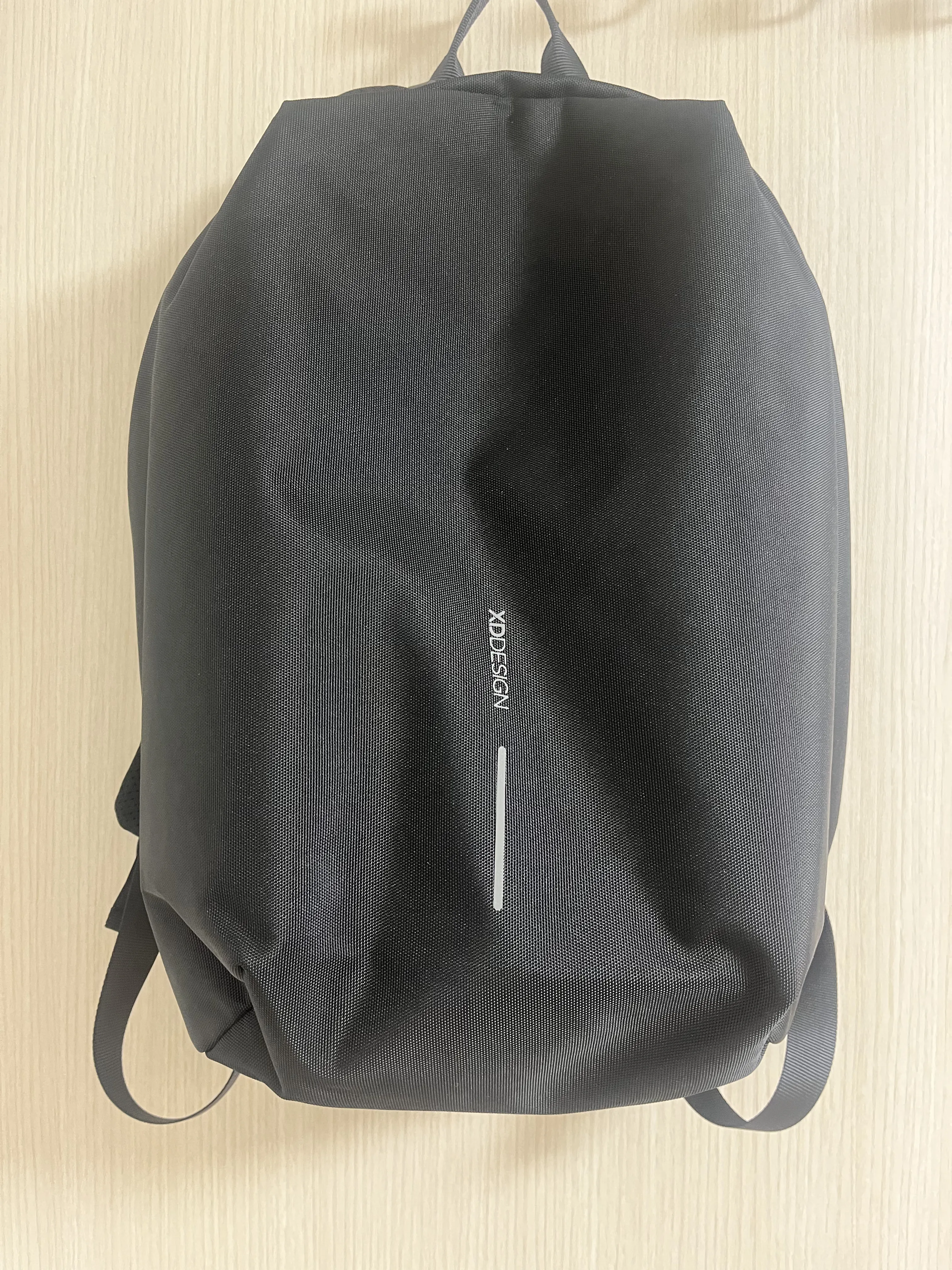 베이지색-문에-걸린-검정-백팩-하나