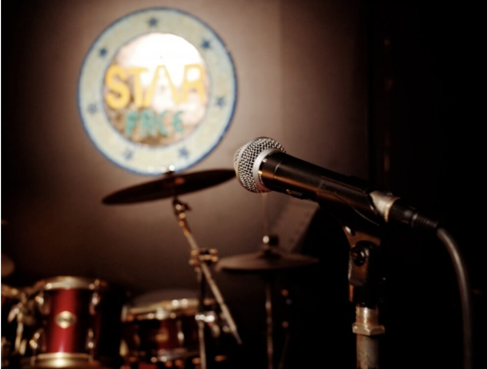 뒤에 드럼이 있고 앞에는 마이크가 있다