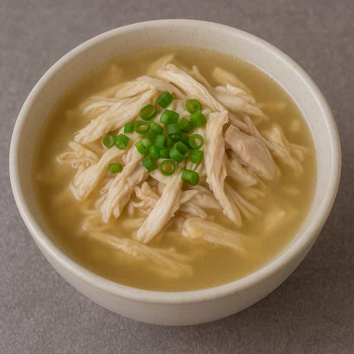 맑은 국물에 잘게 찢은 닭고기와 쪽파가 올라간 따뜻한 닭곰탕 한 그릇