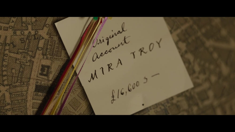 영화 에놀라 홈즈 2 스틸컷 &ndash; 지도를 배경으로 메모가 꽂혀 있는 근접 장면