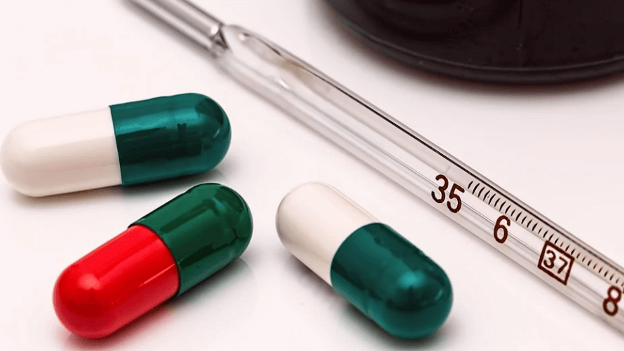 체온계와 캡슐 약 세개가 놓여 있다